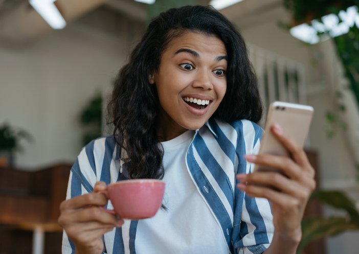 Cafeteras de cápsulas Black Friday: mirando ofertas en el móvil con una taza de café