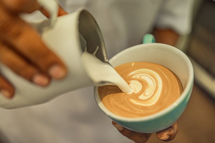 Cuánto cuesta un café en casa: leche vertida sobre una taza de café