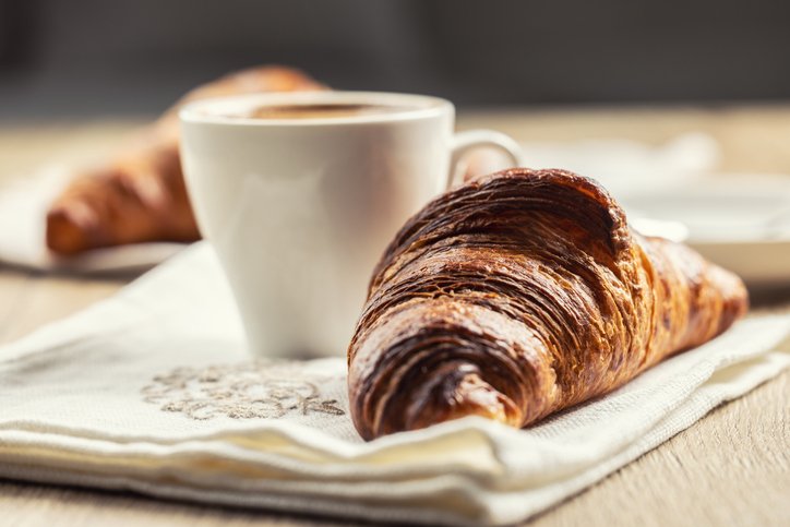 El café sale aguado: taza de café junto a un cruasán
