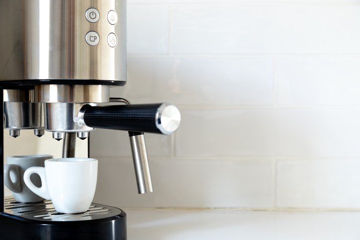 Limpiar el vaporizador de la cafetera: lanceta de vapor junto a una taza