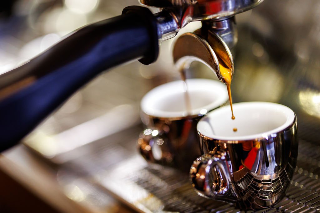 Dos espressos saliendo de una máquina: descalcificar una cafetera mantiene el caudal y la temperatura